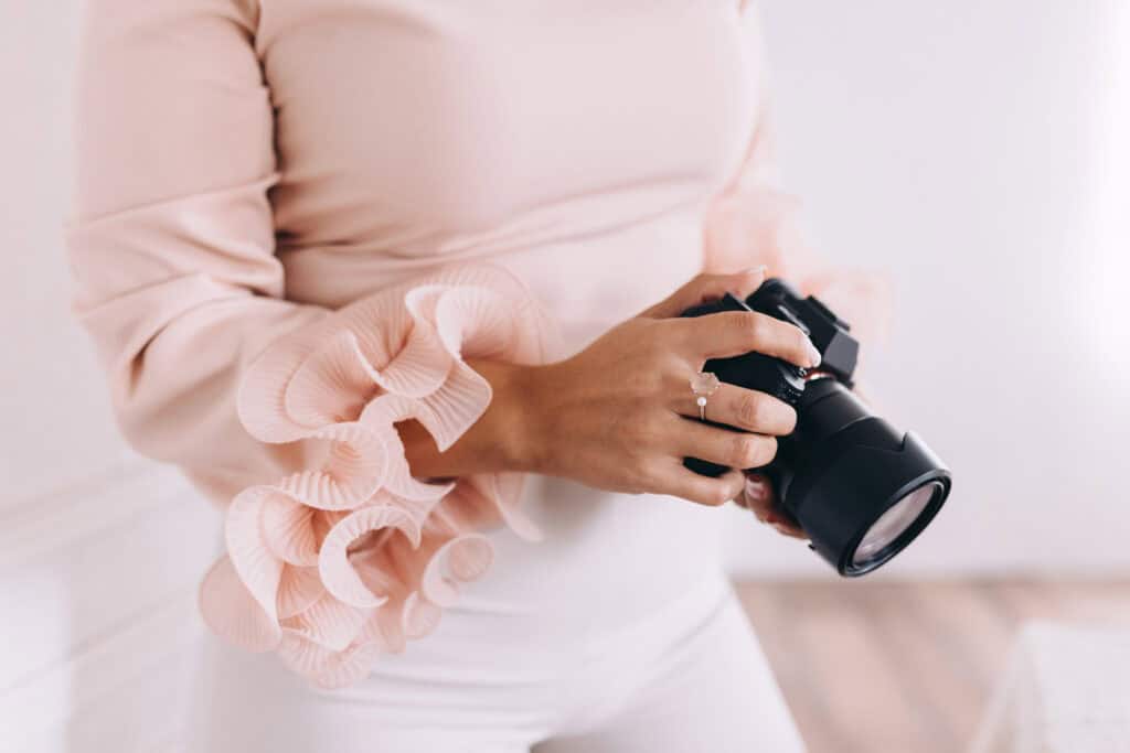 Close-up of a woman with a camera, illustrating creative side hustles for moms in the blog post "Turn Your Creative Passion into Profit" on printandhustle.com.