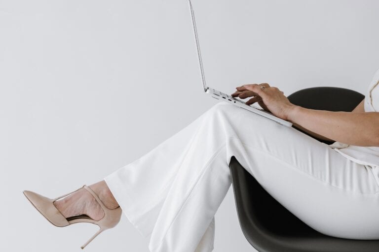 Entrepreneur working on laptop, representing digital planner apps for entrepreneurs and mompreneurs.