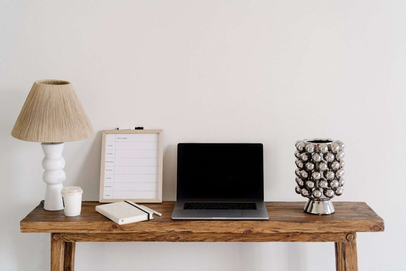 Minimal workspace with laptop and paper planner, showing hybrid planning using digital and printable tools.